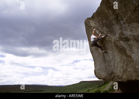 Ein Kletterer, der sich die Rampe des Grand Hotel Boulders am Stanage Edge im Derbyshire`s Peak District hocharbeitet. VEREINIGTES KÖNIGREICH Stockfoto